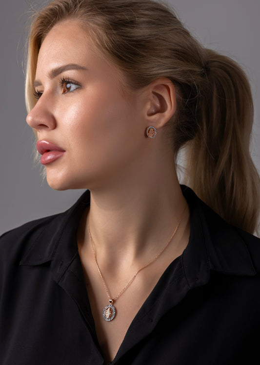 Woman wearing a necklace and earrings against a gray background