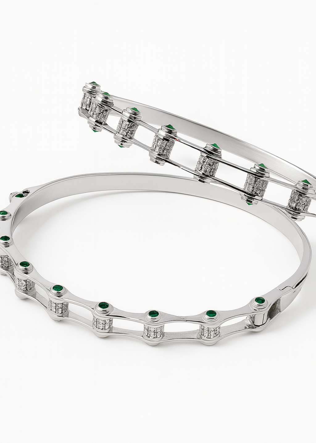 Silver bracelet with green gemstones on a white background