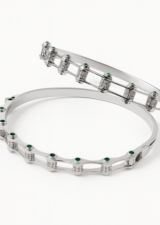 Silver bracelet with green gemstones on a white background
