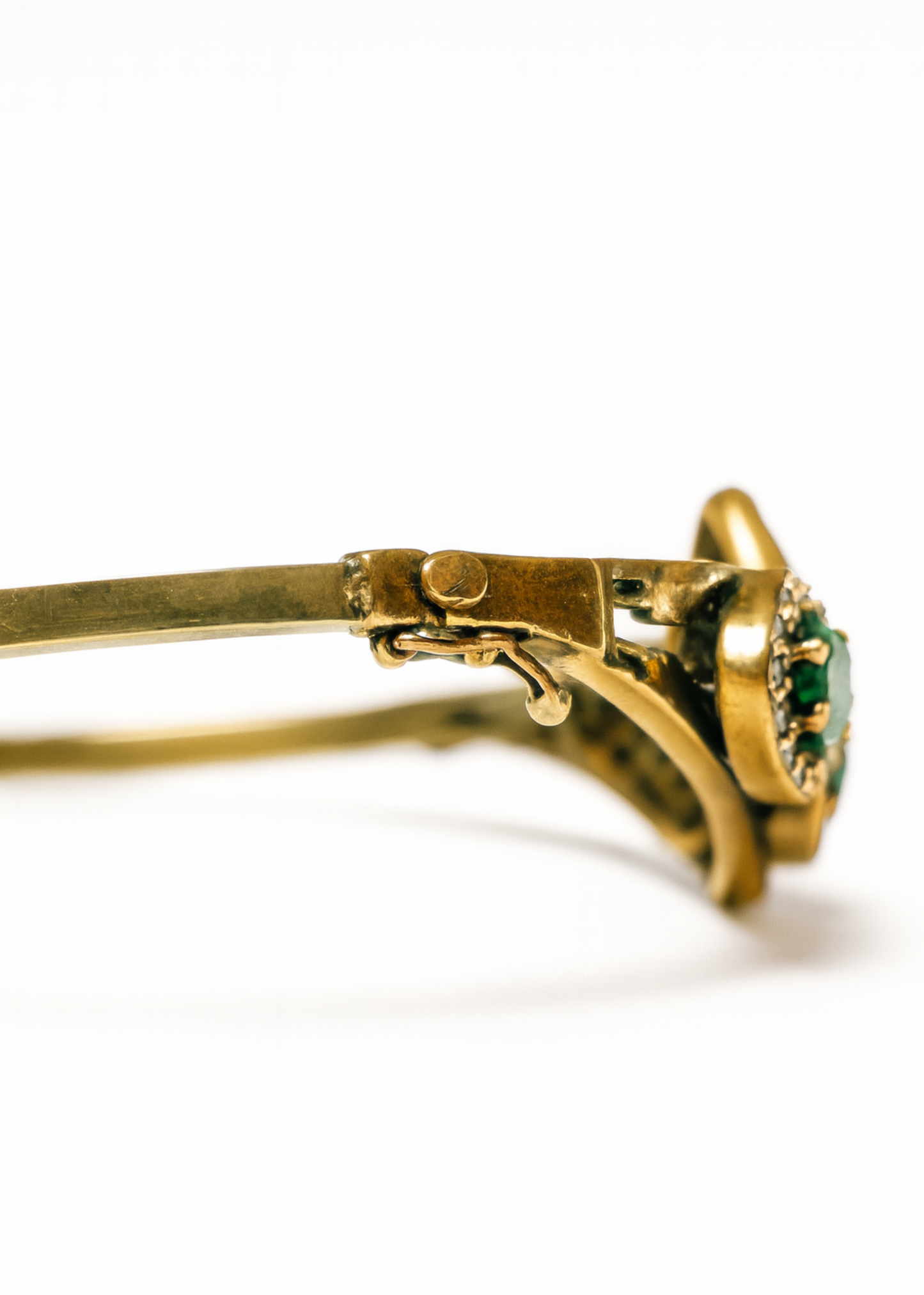 Gold ring with green gemstone on a white background