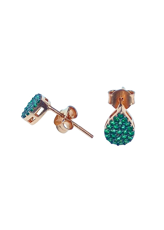 Rose gold earrings with green gemstones on a light blue background