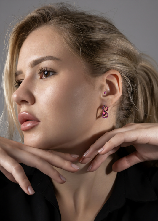 Close-up of a woman wearing pink earrings with a neutral background