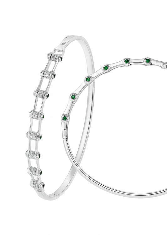 Silver bracelet with green gemstones on a white background
