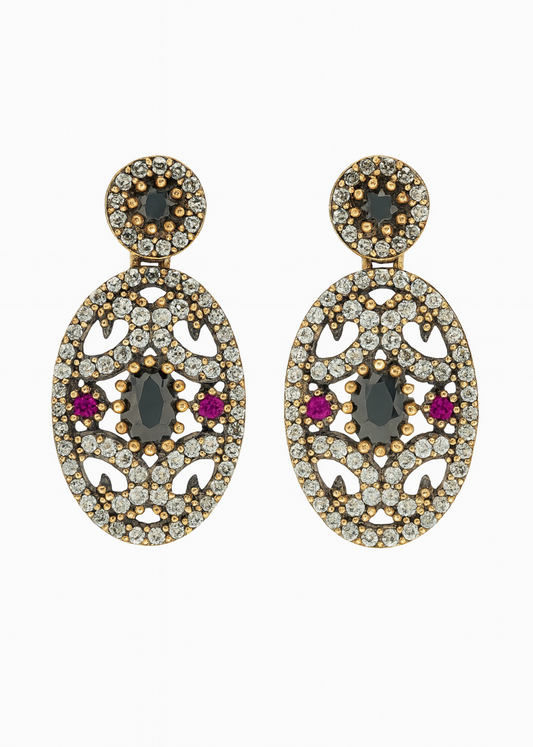 Pair of ornate earrings with gemstones on a white background