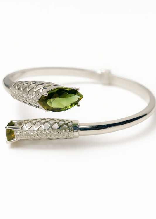 Silver bracelet with green gemstones on a white background