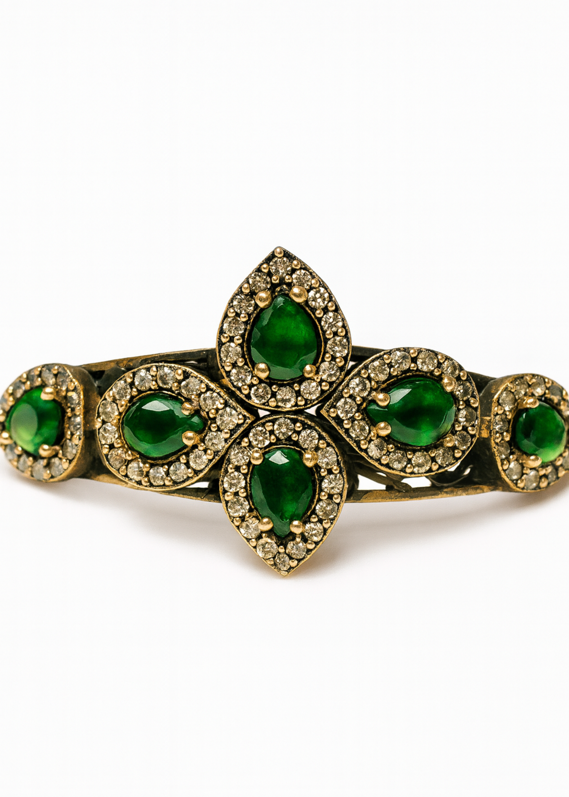 Gold bracelet with green gemstones on a white background