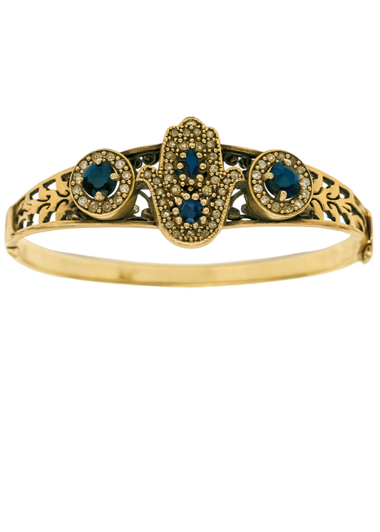 Gold bracelet with blue gemstones on a white background
