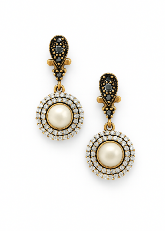 Pair of earrings with pearl-like centers and gold accents on a white background