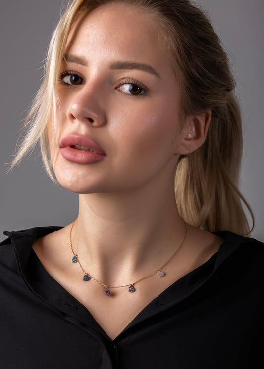 Woman wearing a necklace against a gray background
