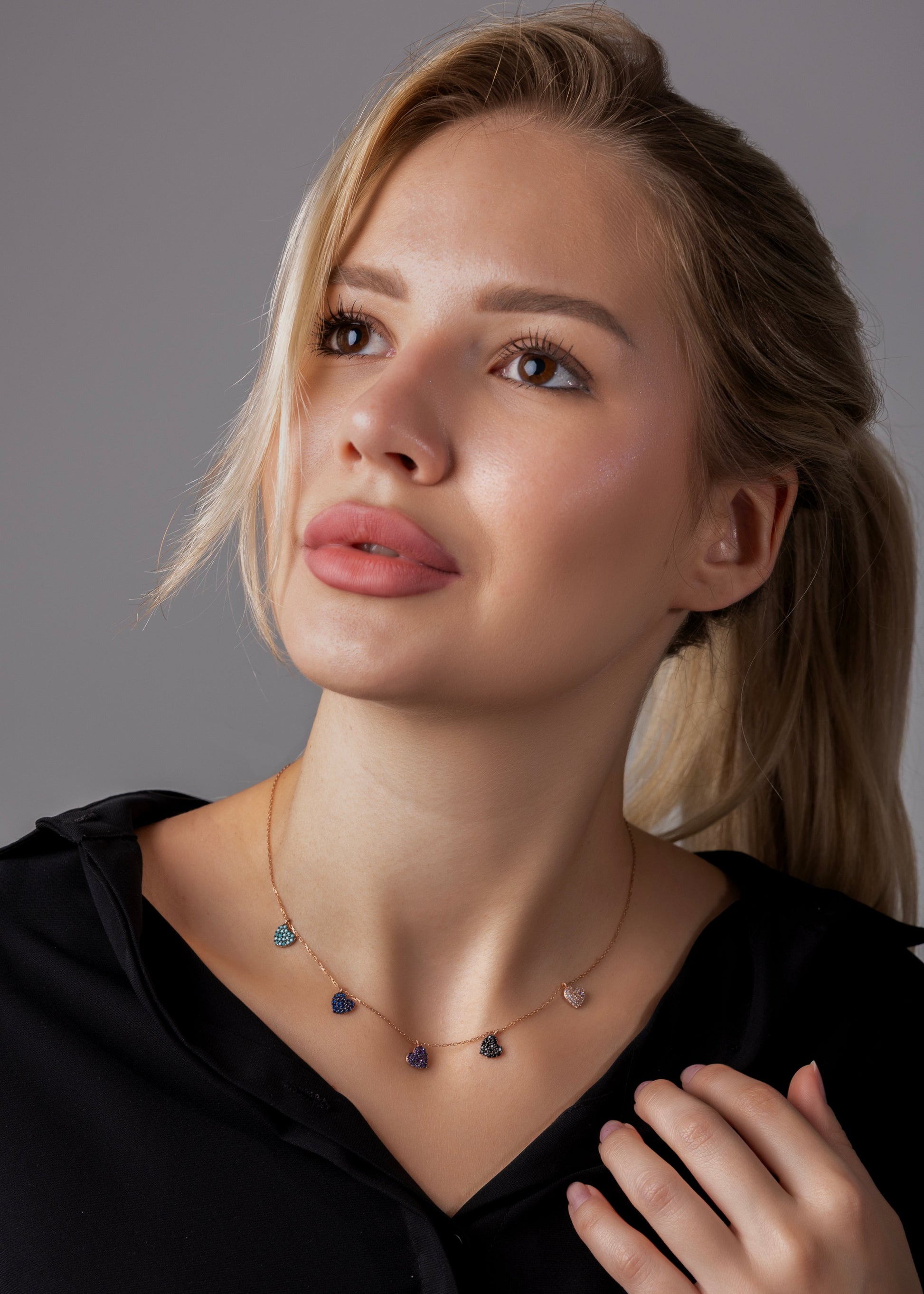 Woman wearing a necklace with a gray background