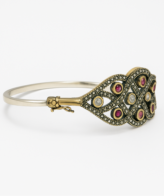 Gold and silver bracelet with gemstones on a white background