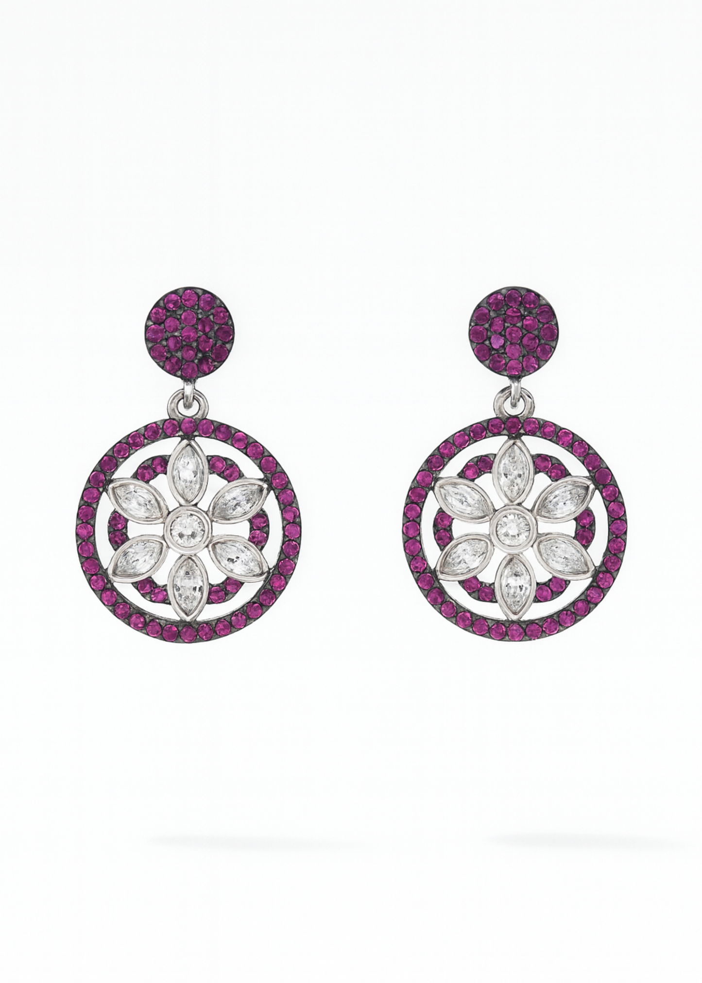 Pair of earrings with floral designs and pink gemstones on a white background