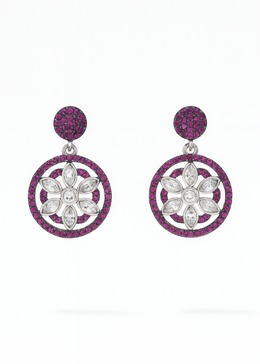 Pair of earrings with floral designs and pink gemstones on a white background