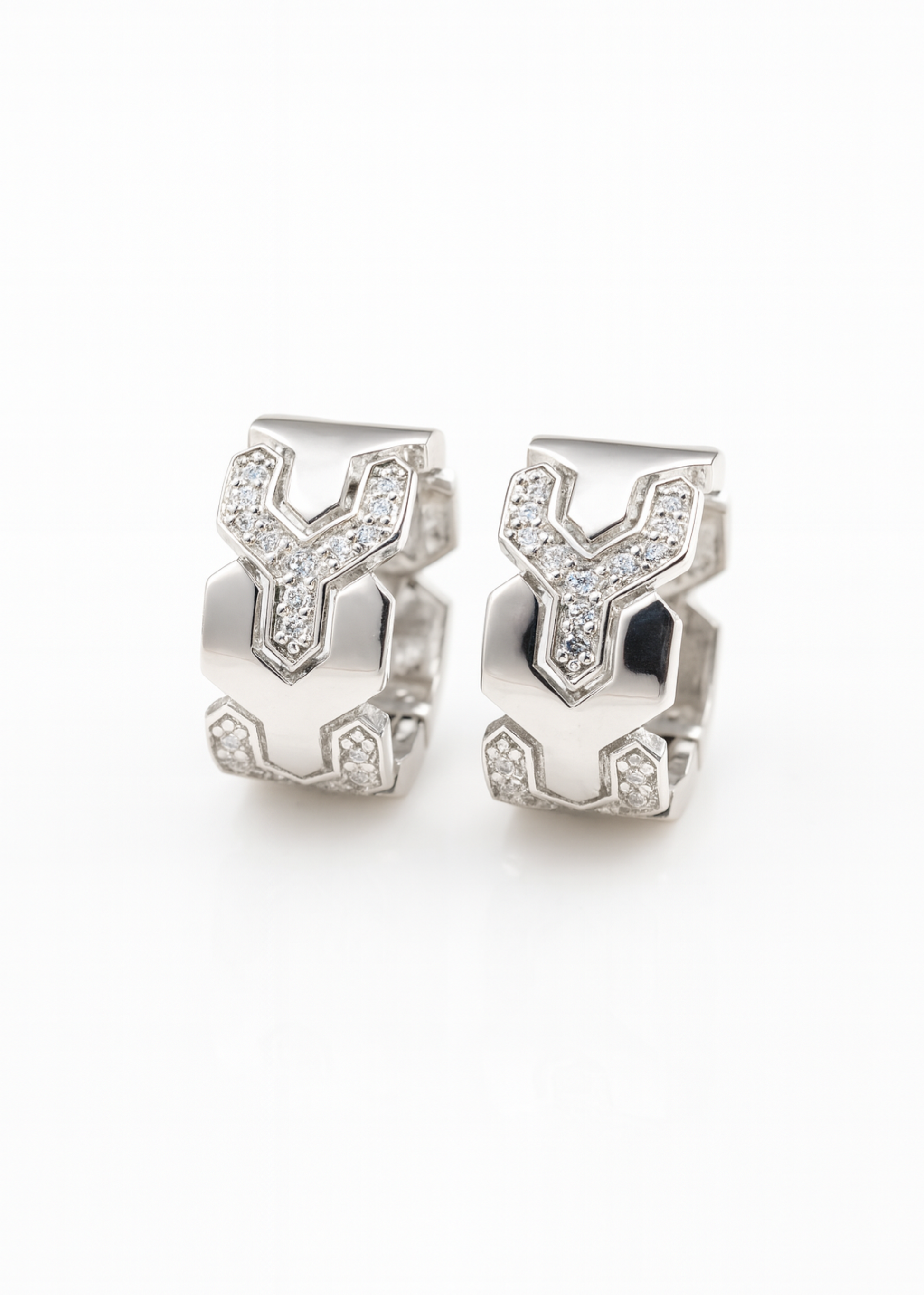 Pair of silver earrings with geometric design on a white background