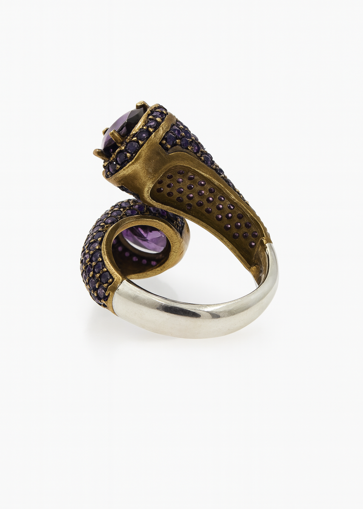 Gold and silver ring with purple gemstones on a white background
