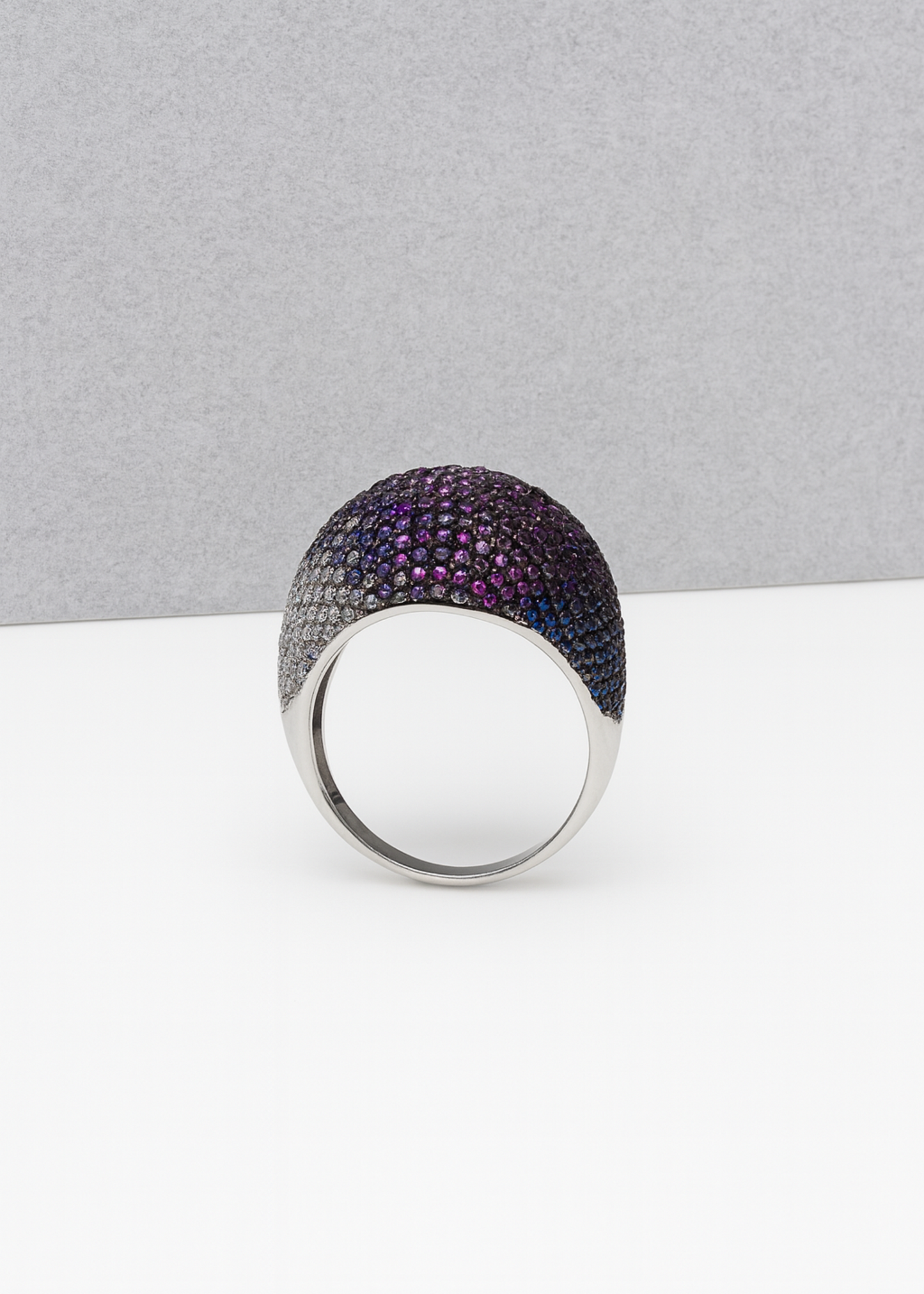Silver ring with purple gemstones on a gray background
