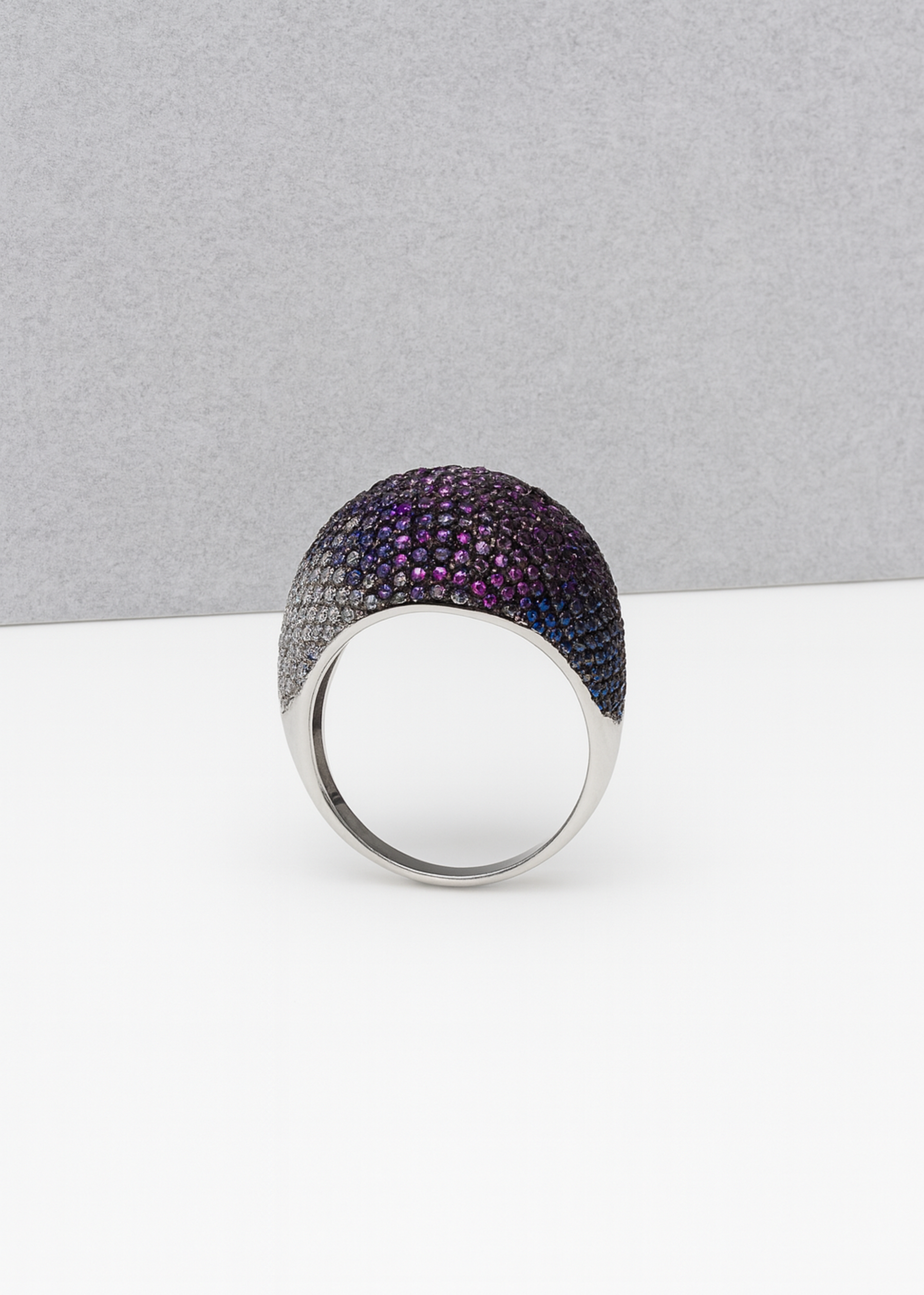 Silver ring with purple gemstones on a gray background