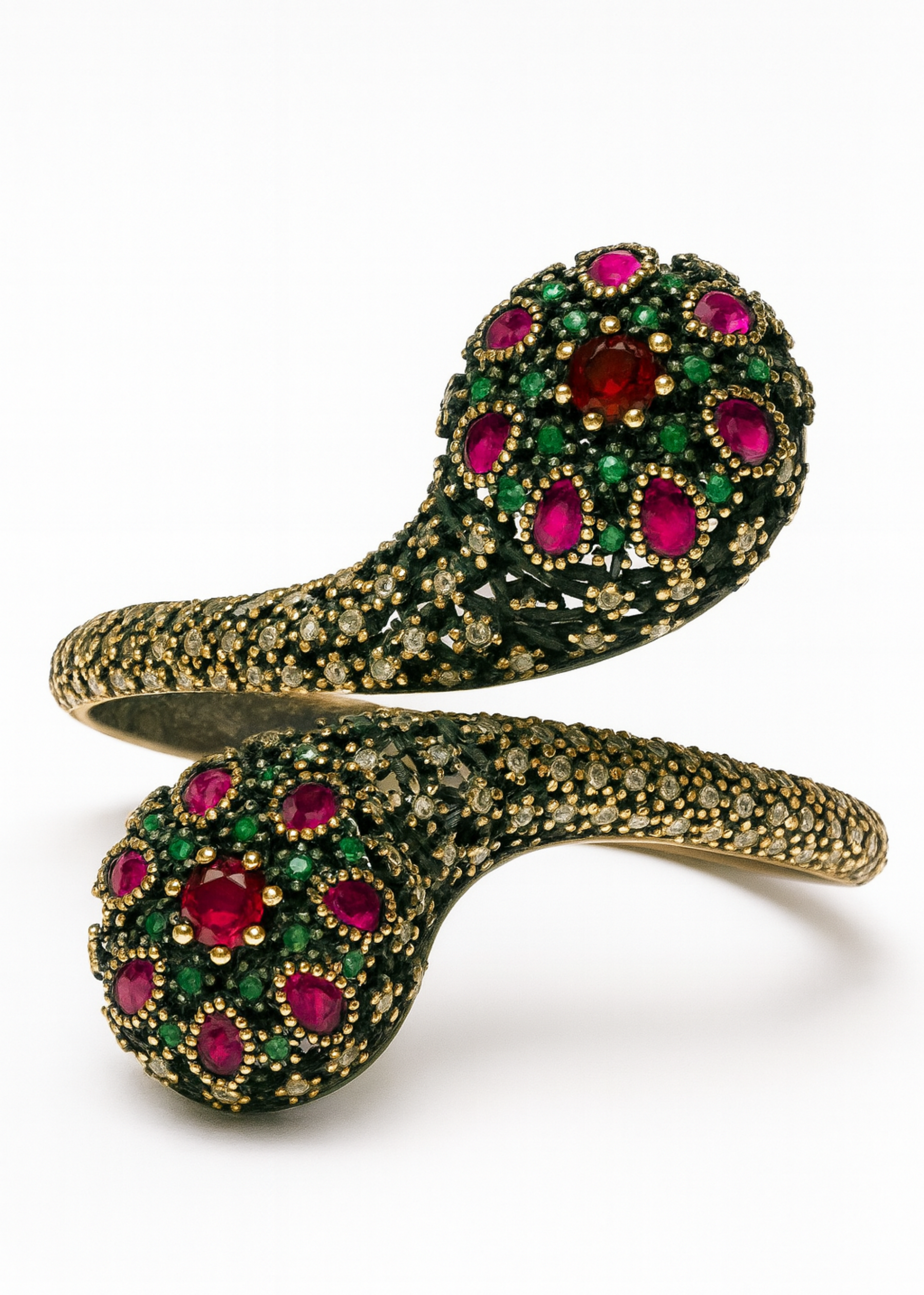 Gold bracelet with red and green gemstones on a white background