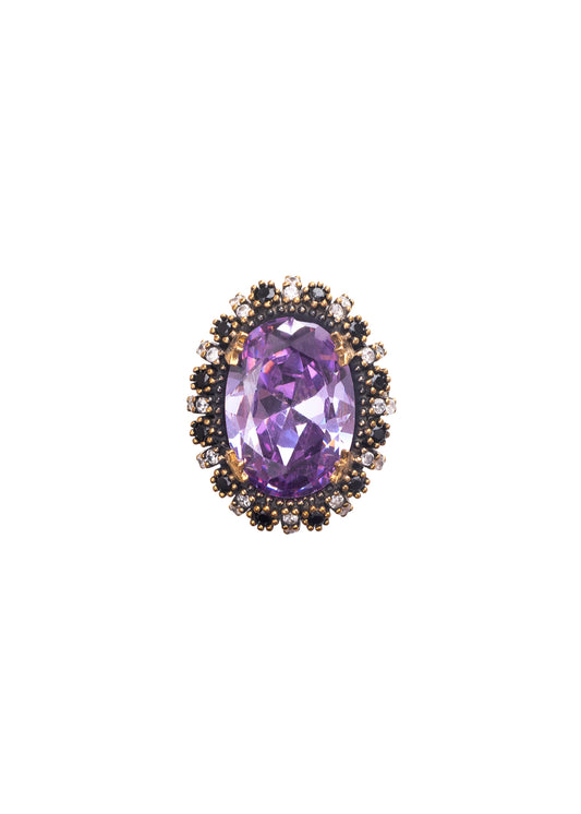 Purple gemstone in a decorative metal setting on a white background