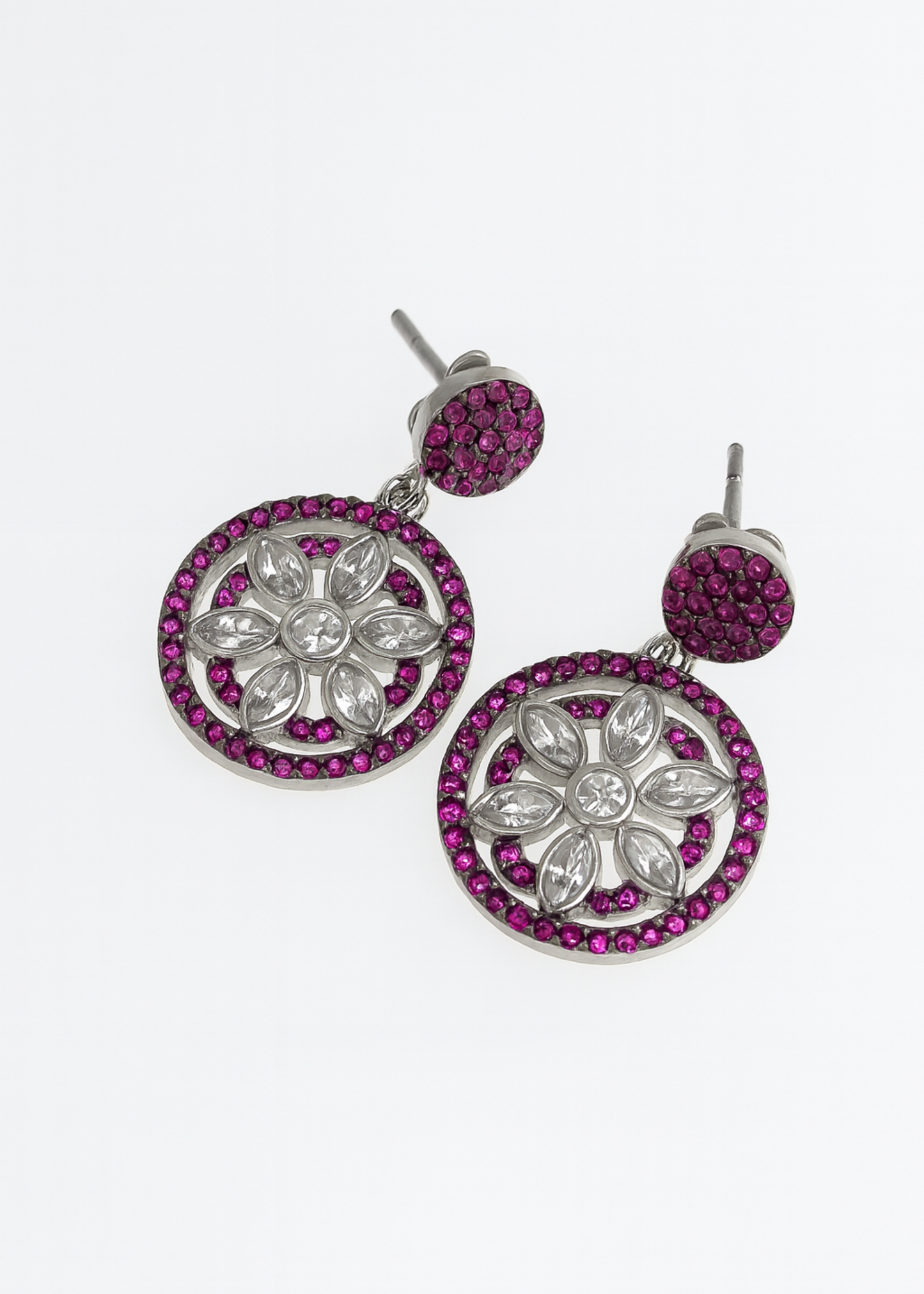 Pair of earrings with floral design and pink gemstones on a white background