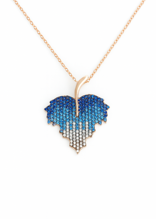Heart-shaped pendant with blue and white gradient on a gold chain against a white background