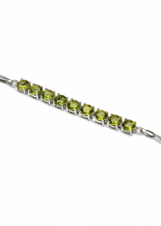 Silver bracelet with green gemstones on a white background