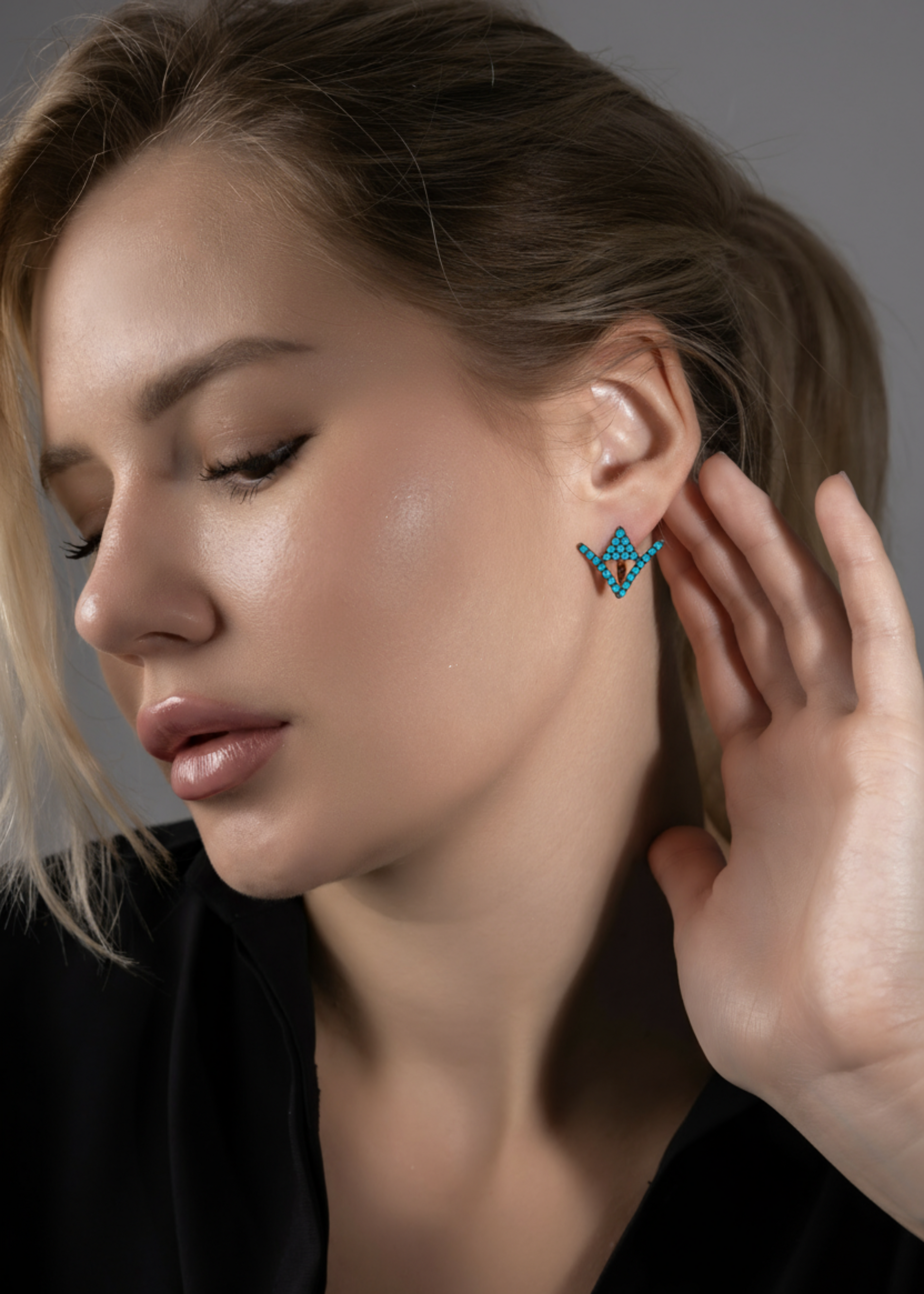 Woman wearing a butterfly-shaped earring with a neutral background